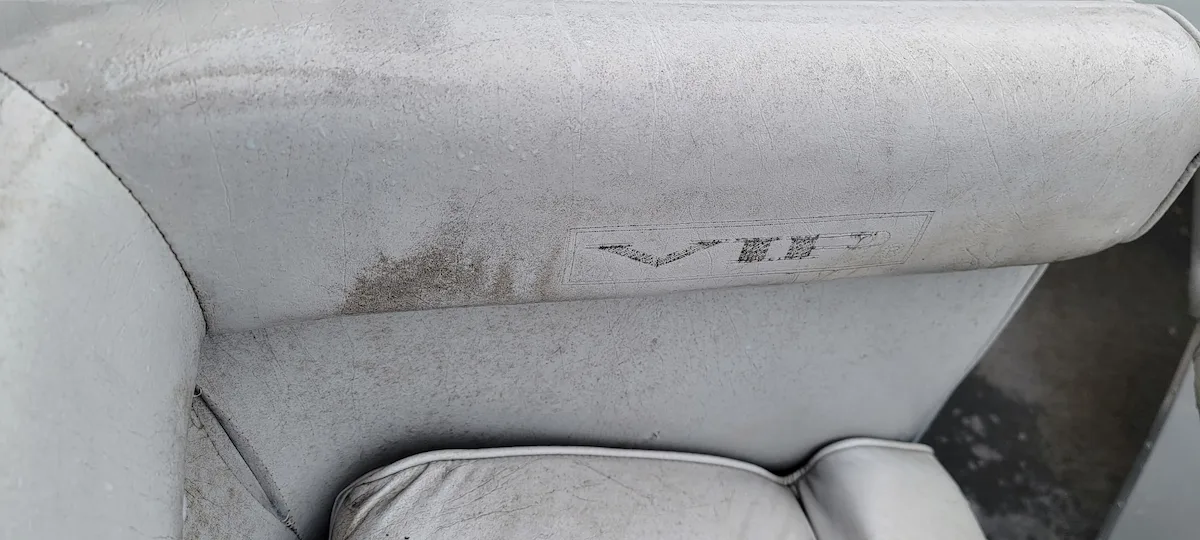 Stained and faded vinyl boat seats before cleaning